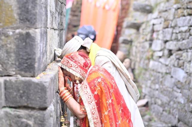 Bride and groom seeking blessings at the temple wall