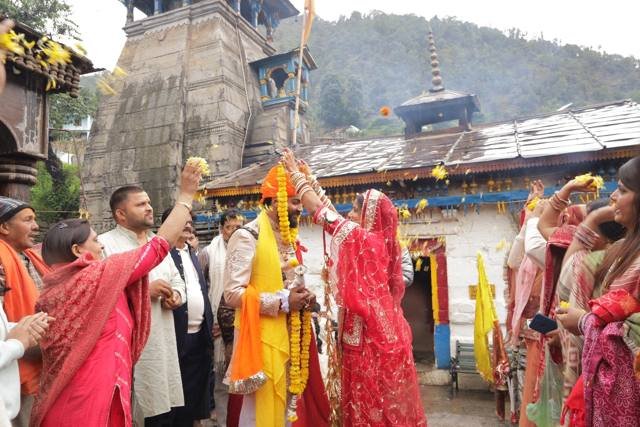 Bride and groom showered with marigold petals at Triyuginarayan temple