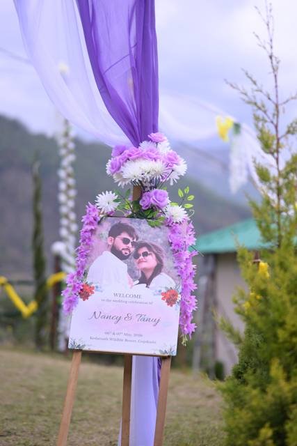 Welcome board with lilac floral decor at a wedding